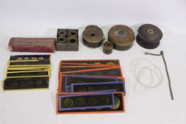 Various projector parts to include film reels, a quantity of glass slides, and similar.