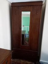 A wardrobe with carved decoration, single door with mirror to the exterior,