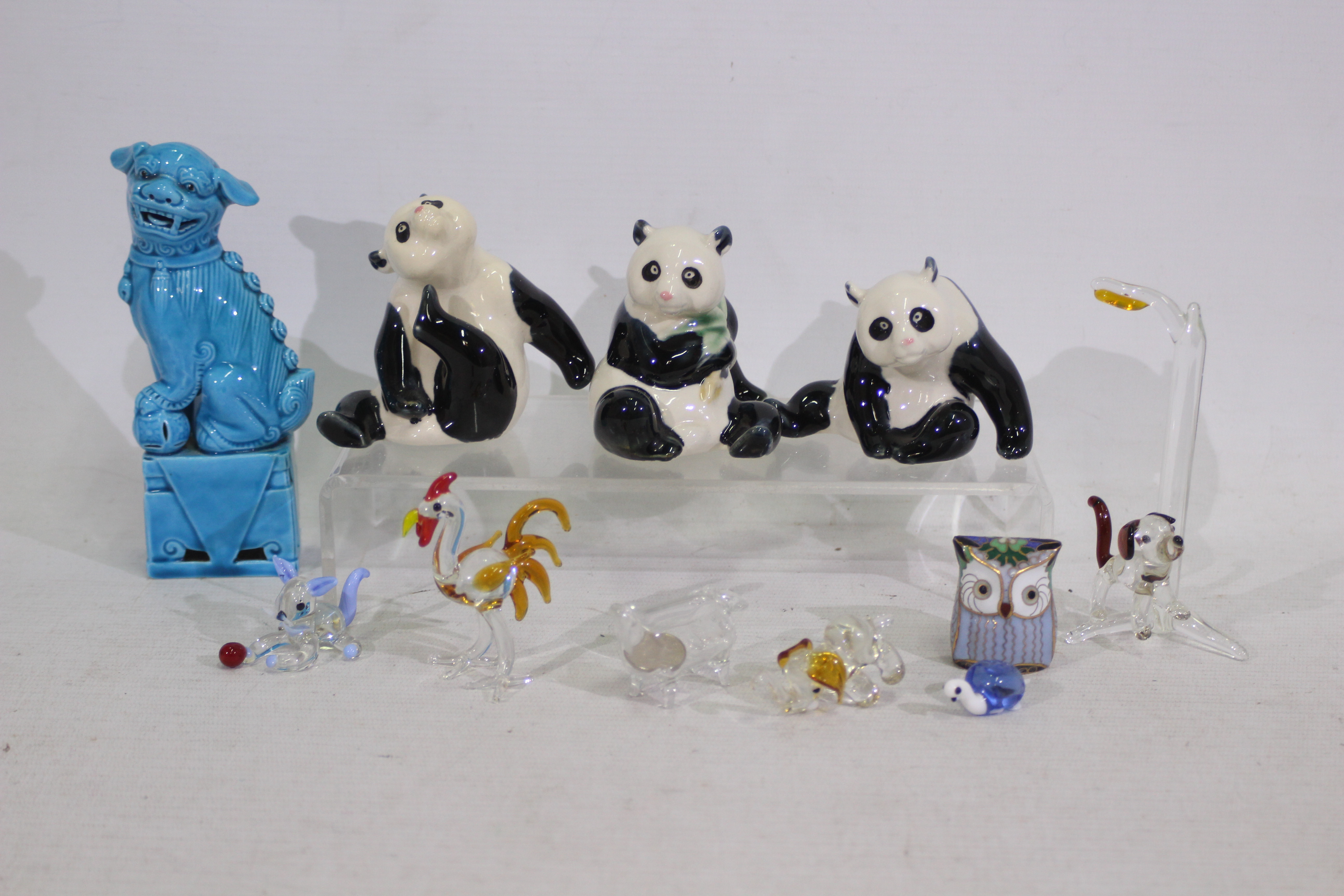 A lot including a Chinese blue mounted Fu dog. 3 x Chinese ceramic pandas.