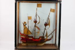 A large model of a three masted ship, housed in a glass display case,