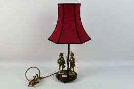 A brass lamp with wooden base. Lamp has