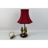 A brass lamp with wooden base. Lamp has