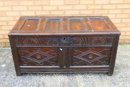 An antique oak coffer or blanket box with carved decoration, approximately 60 cm x 121 cm x 58 cm.
