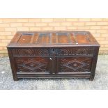 An antique oak coffer or blanket box with carved decoration, approximately 60 cm x 121 cm x 58 cm.