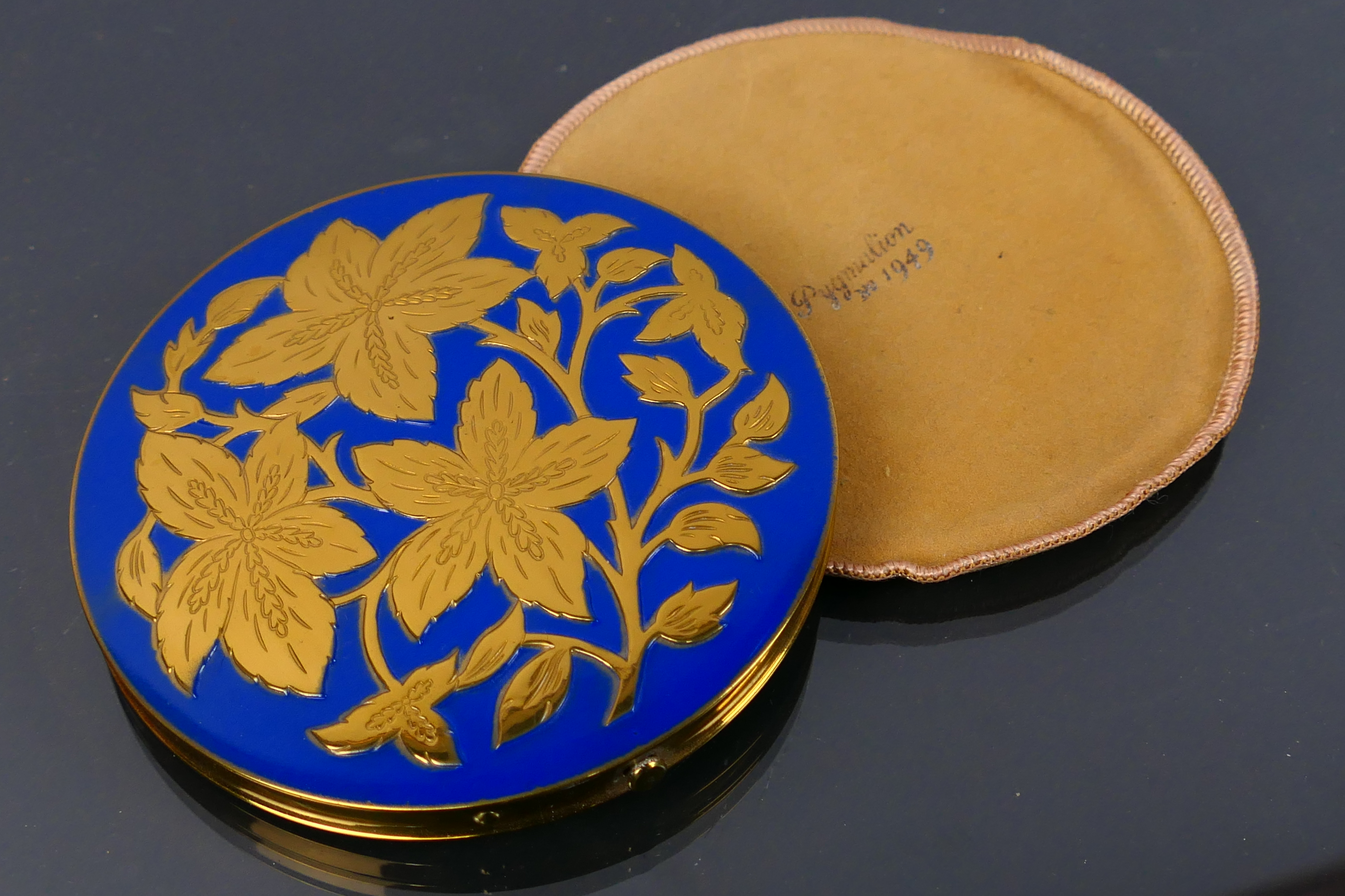 A boxed vintage Pygmalion 1949 gilt metal and enamel powder compact. Made in England.