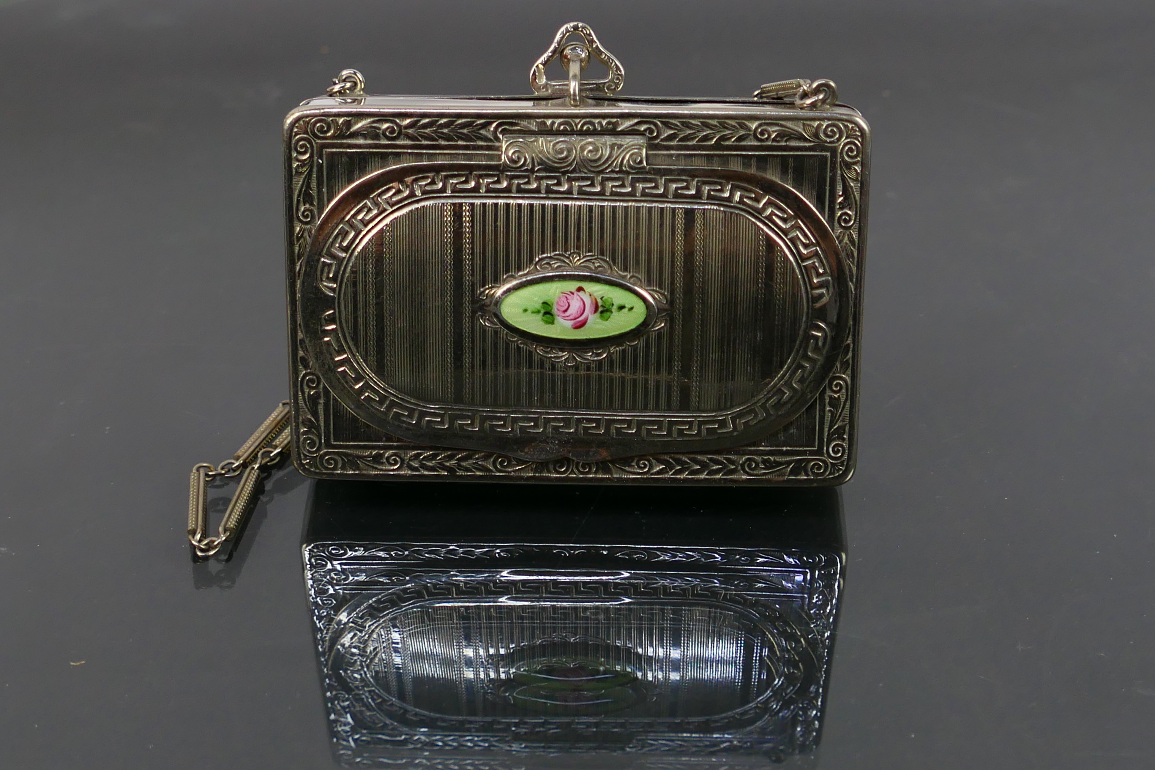 A cocktail purse style powder compact and sovereign holder on a chain.