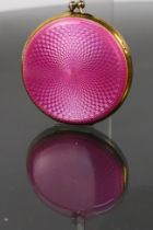 An art deco silver powder compact. Has a pink enamelled art deco pink base. A top single hinged lid.