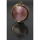 A miniature guilloche enamel powder compact, covered front and back in pale pink enamel.