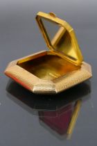 A 9ct gold powder compact engine turned with an interior mirror and powder compartment. 22.6 grams.