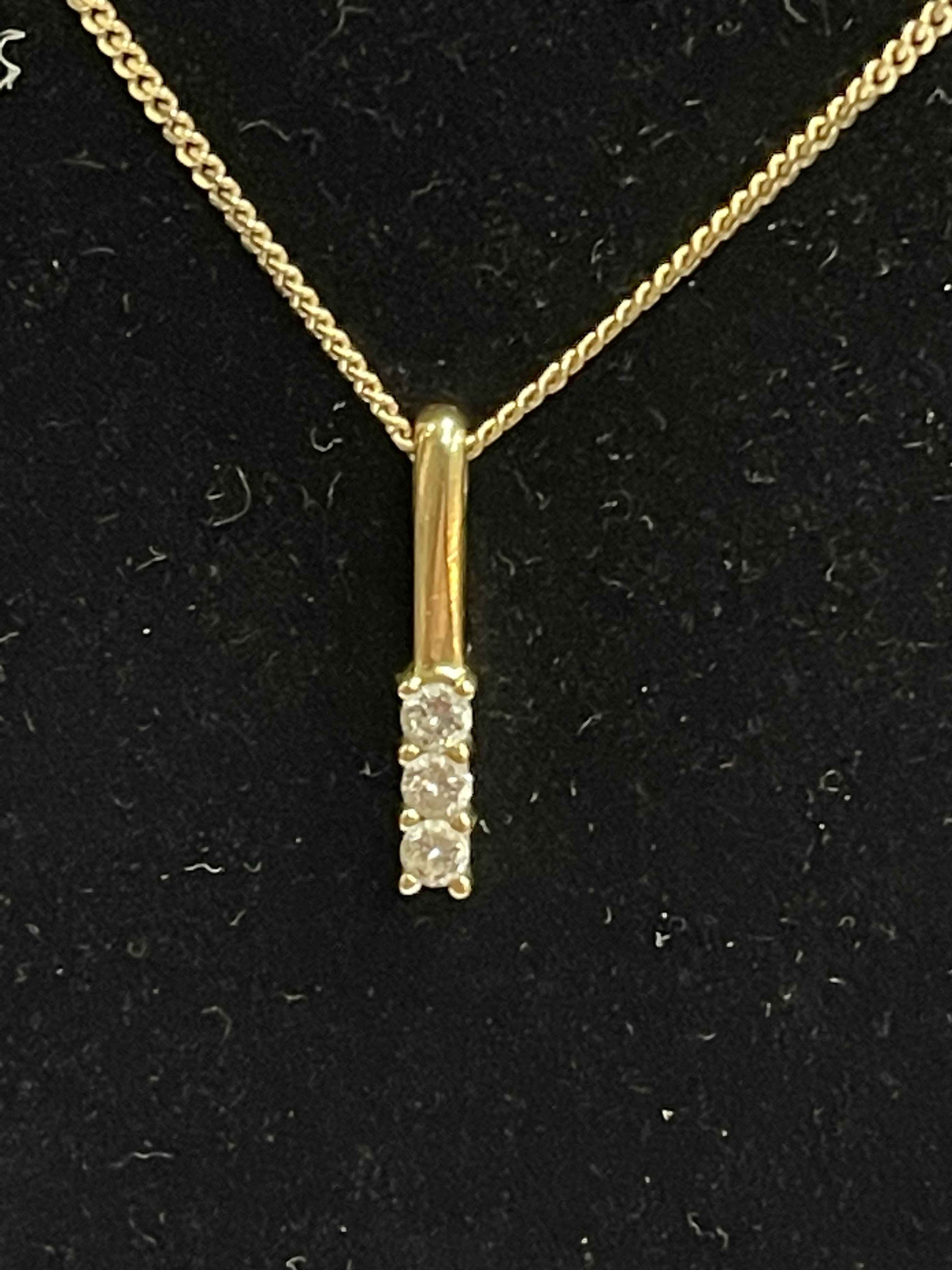 Diamond three stone 18 carat gold pendant with 9 carat gold chain.