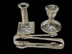 Two silver dwarf candlesticks and two pairs of silver tongs.