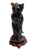 Chinese carved cherry amber figure on wood base, 20cm high.