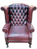 Thomas Lloyd ox blood deep buttoned leather and studded wing armchair.