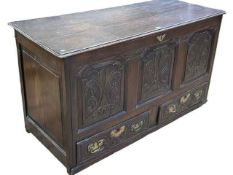 Antique oak carved triple panel front kist having two base drawers, 75cm by 140cm by 55cm.