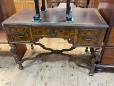 Walnut three drawer writing desk on ornate shaped legs joined by shaped cross stretcher,