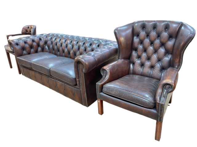 Brown deep buttoned leather three seater Chesterfield settee and wing armchair together with a