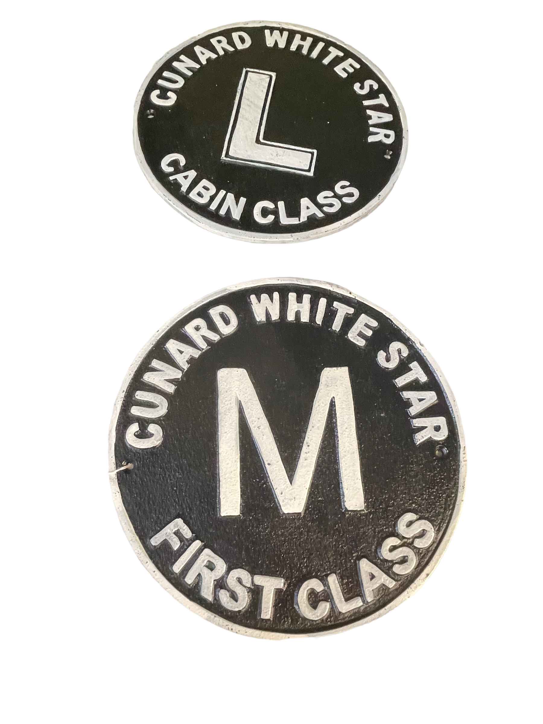 Two circular cast Cunard signs.