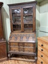 1920's Lees style carved oak bureau bookcase having two glazed panel doors above a fall front