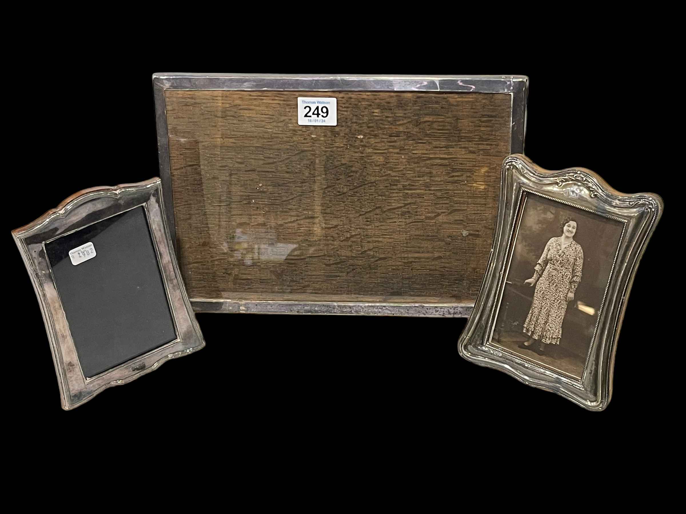 Three silver easel photograph frames, two shaped, one rectangular.