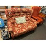 Two seater settee in floral pattern fabric and wing armchair.