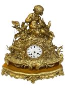 Large ornate gilt metal mantel clock with mounted cherub on giltwood base.