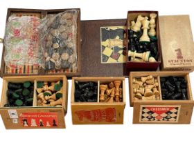 Four chess sets including two in Staunton boxes, draughts and board.
