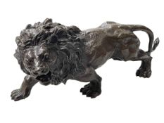 Bronze model of a lion, 32cm long.