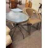 Circular glass topped wrought metal and wickerwork patio table and three chairs.