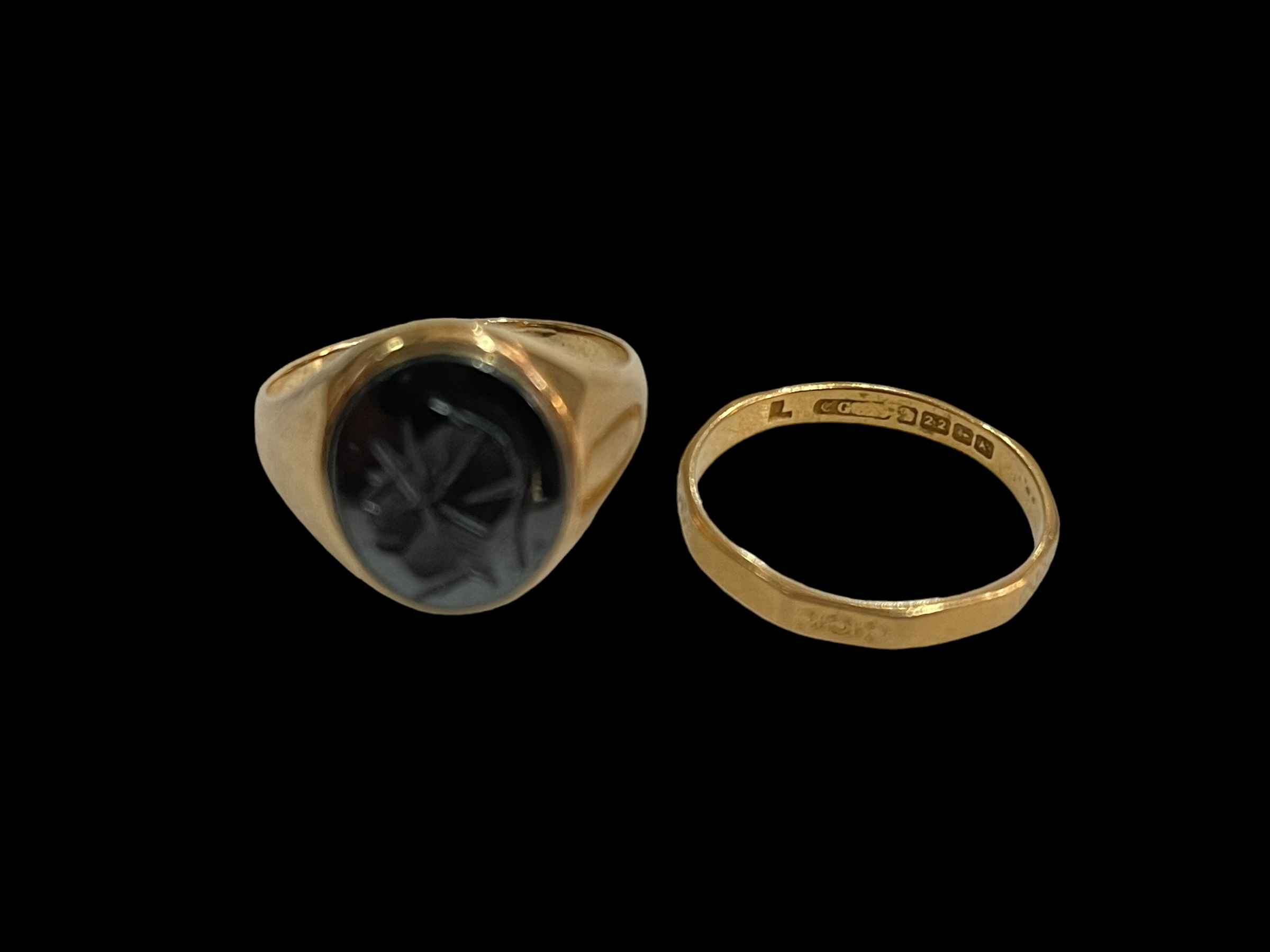 9 carat gold oval carved black stone signet ring, size R and 22 carat gold wedding band, size R.