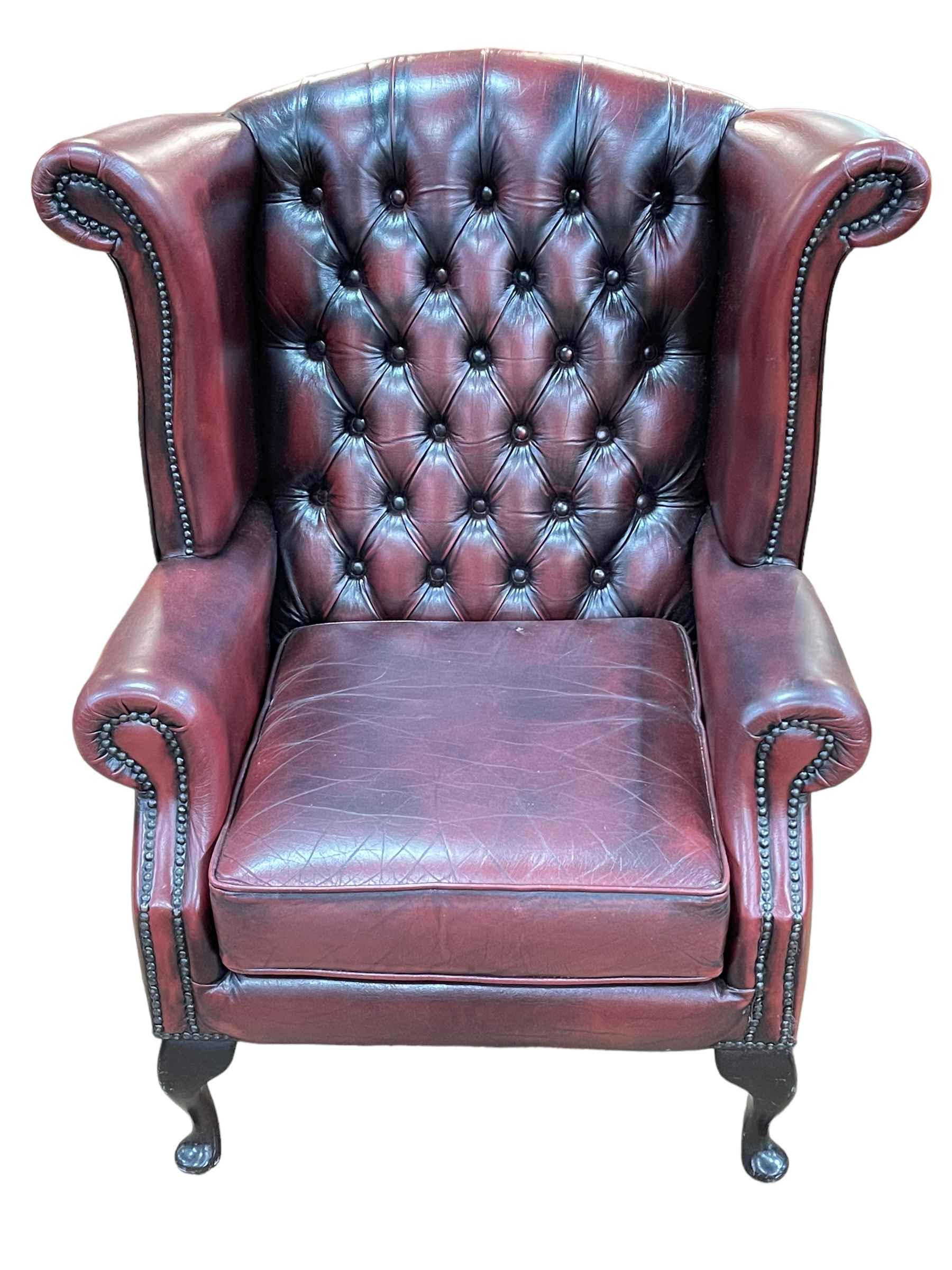 Thomas Lloyd ox blood deep buttoned leather and studded wing armchair.