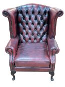 Thomas Lloyd ox blood deep buttoned leather and studded wing armchair.