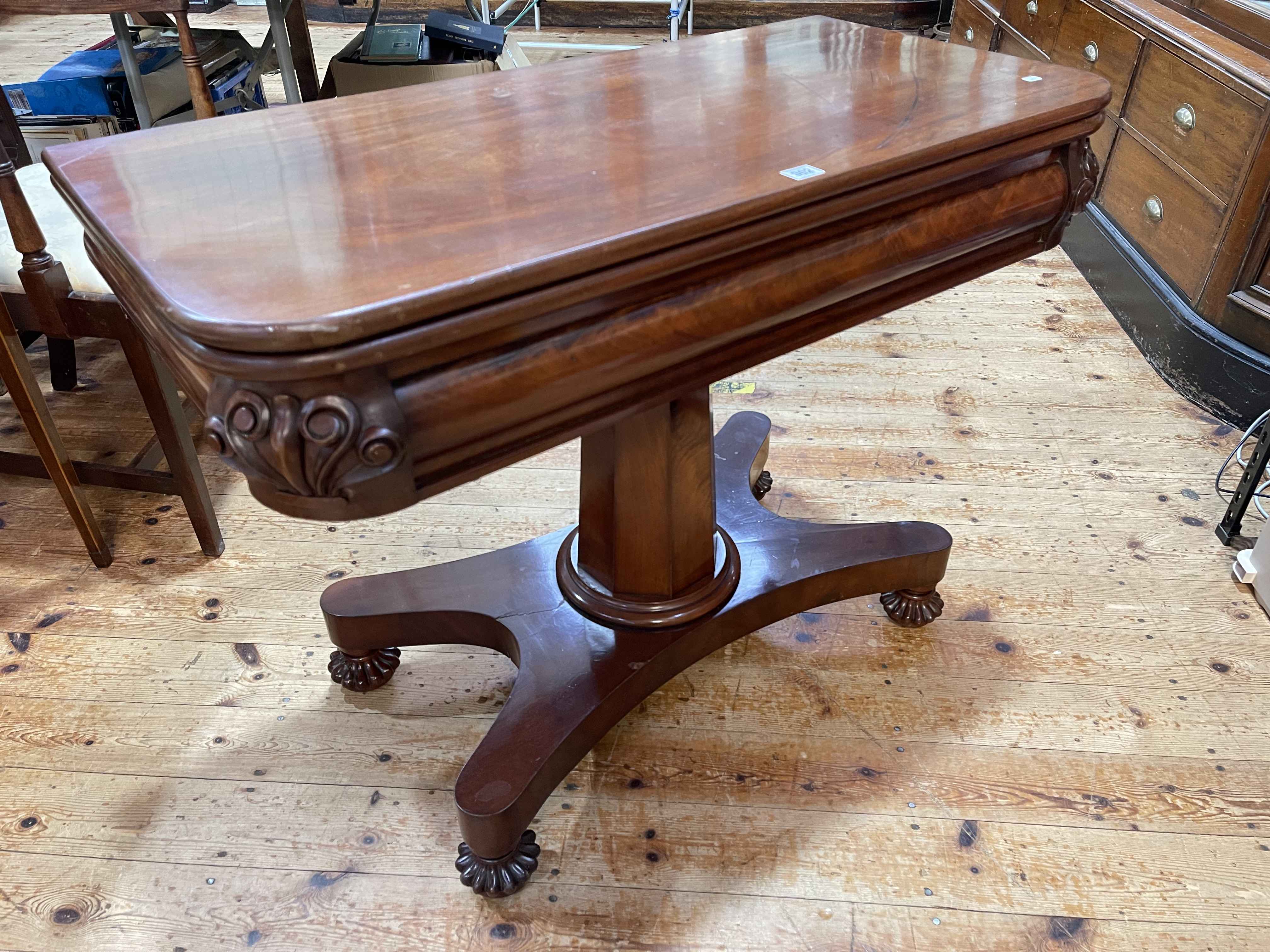 Victorian mahogany fold top tea table on tapering octagonal pedestal to inverted quadriform base,
