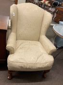 Wing back armchair in light classical fabric.