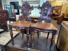 Pair Victorian mahogany carved panel back hall chairs.