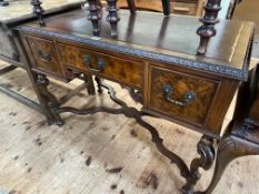 Walnut three drawer writing desk on ornate shaped legs joined by shaped cross stretcher,