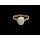 Oval opal claw set ring in 9 carat yellow gold, size O.