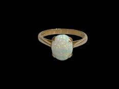 Oval opal claw set ring in 9 carat yellow gold, size O.