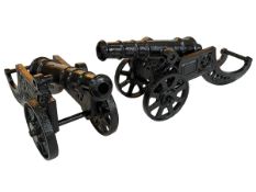 Pair of cast metal canons, 19cm high.