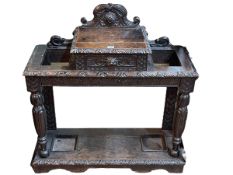 Victorian carved oak hallstand having central drawer flanked by two stick stands,