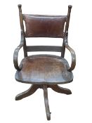 Early 20th Century oak swivel office desk chair with hide panel back.