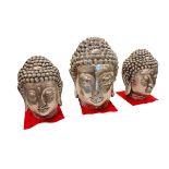 Three silvered Buddha heads.