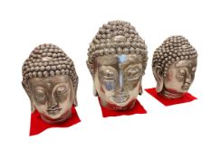 Three silvered Buddha heads.