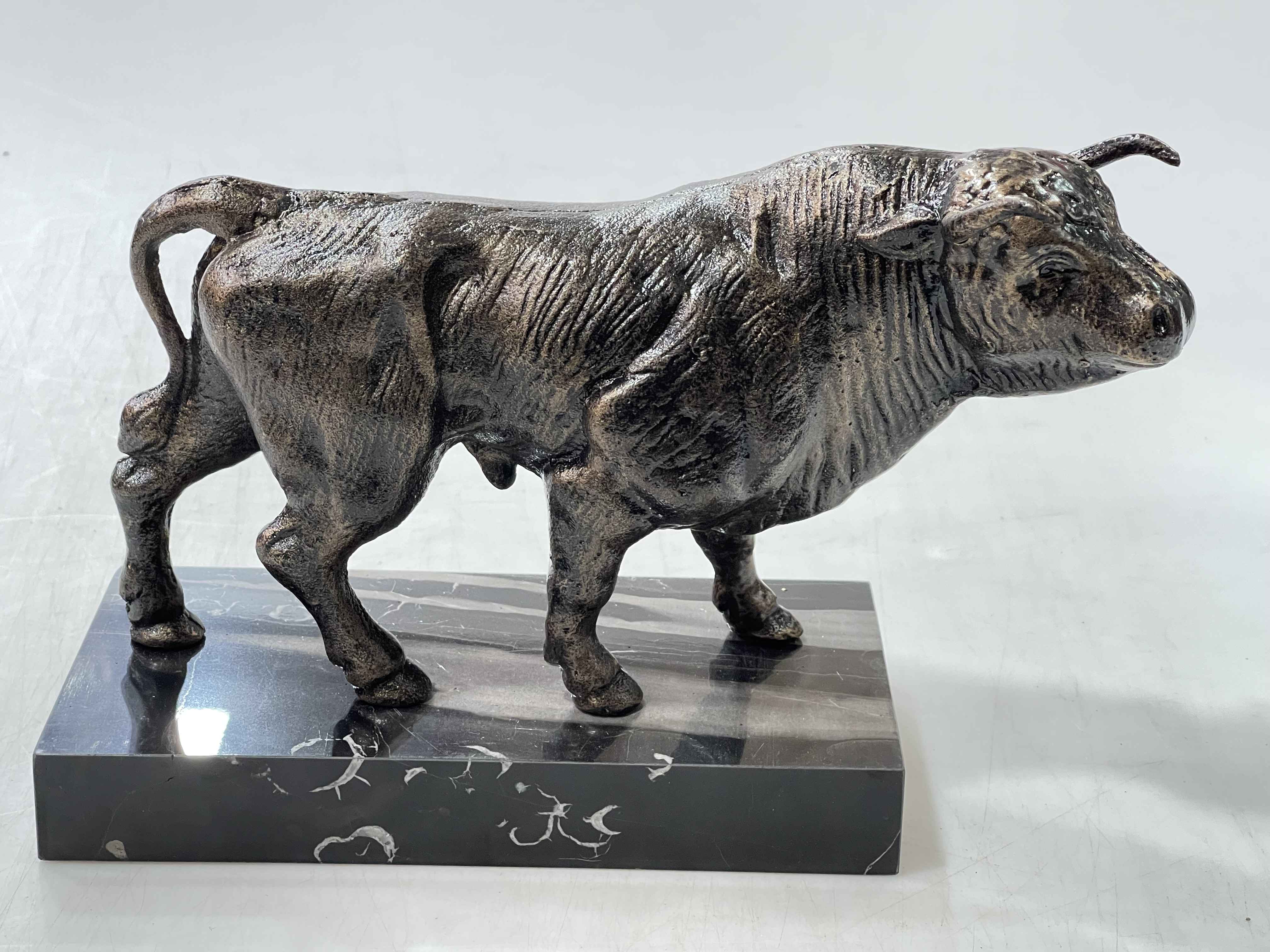 Bronze bull on marble base, 28cm overall length.