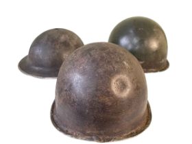 Three tin military helmets.