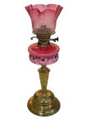 Ornate Victorian oil lamp with painted pink porcelain reservoir and a pink etched shade, 56cm high.