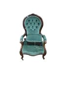 Victorian mahogany framed open armchair in green buttoned fabric together with a footstool to match