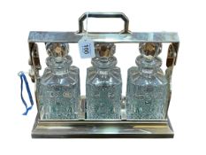 Three bottle tantalus in silver plated stand, 30cm high.