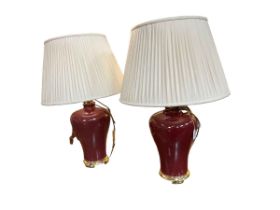 Pair of red and gilt table lamps with shades.