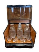 Continental floral inlaid and ebonised decanter box with three decanters and six glasses,