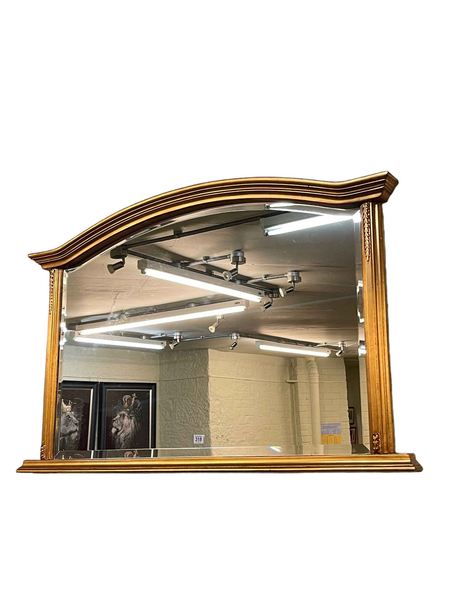 Gilt framed arched top bevelled overmantel mirror, 77cm by 122cm.